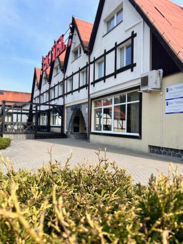 a large white building with a red roof at Hotel Górecki in Lidzbark Warmiński