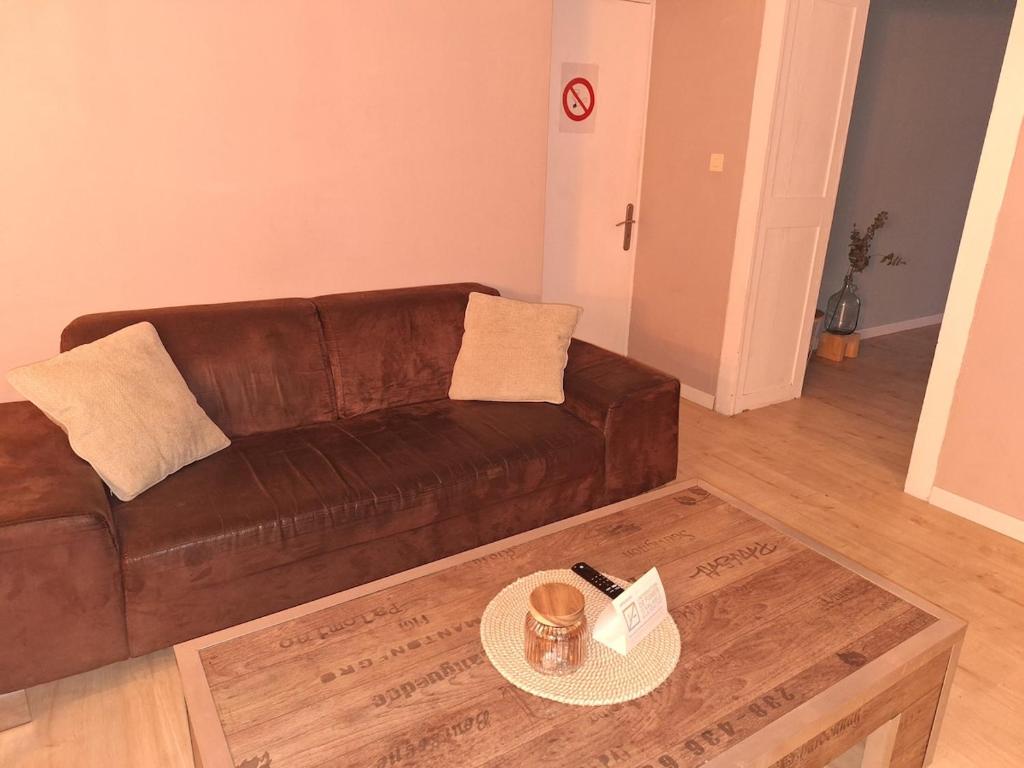 a living room with a brown couch and a coffee table at Cozy countryside apartment in Moriville