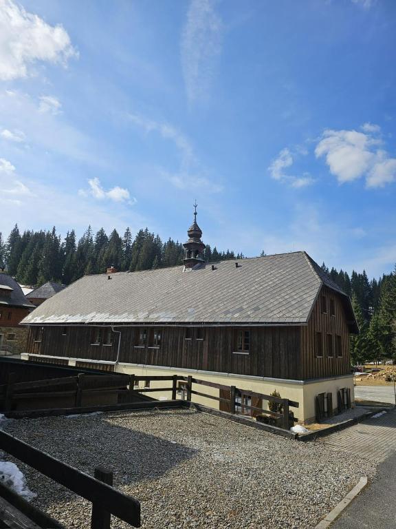 a large wooden barn with a tower on top of it at Penzion Pupík in Modrava