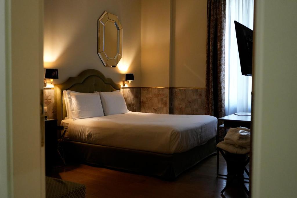 een hotelkamer met een bed en een spiegel bij The Talent Hotel in Rome