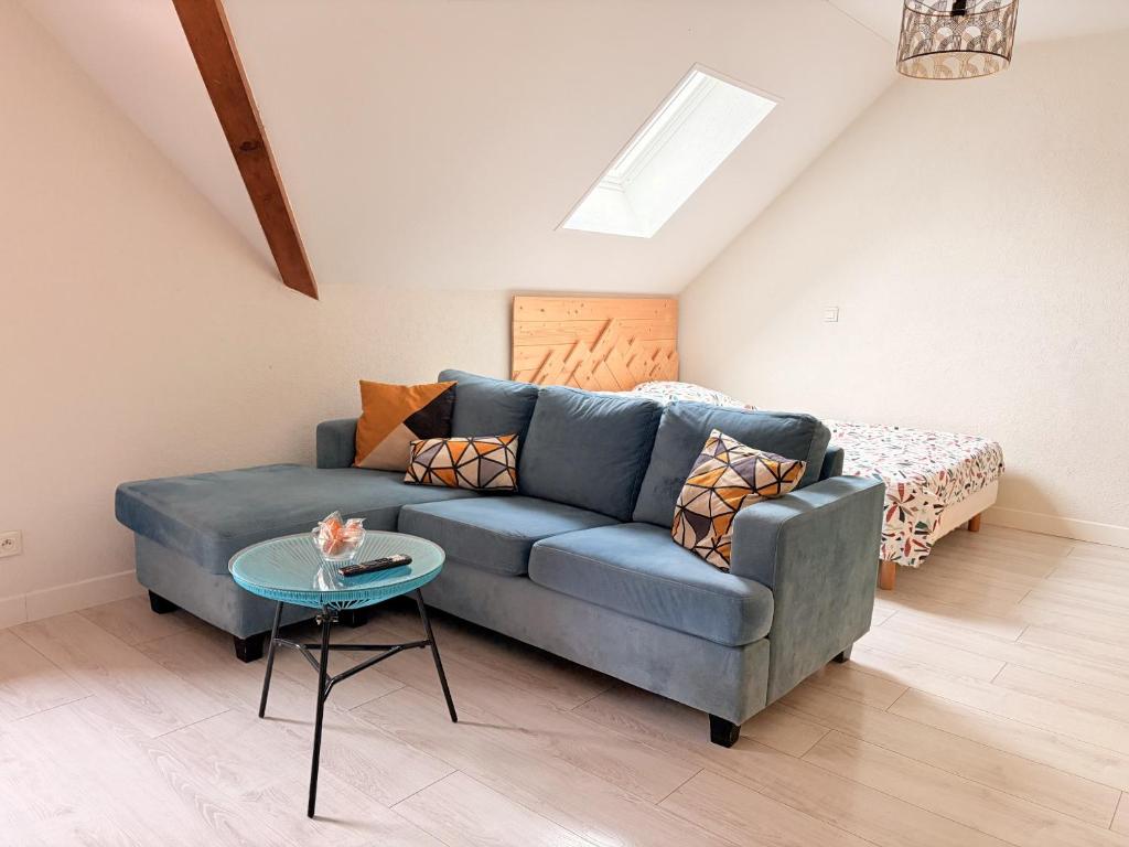 a living room with a blue couch and a bed at Birdie H N21 ST2 in Giez