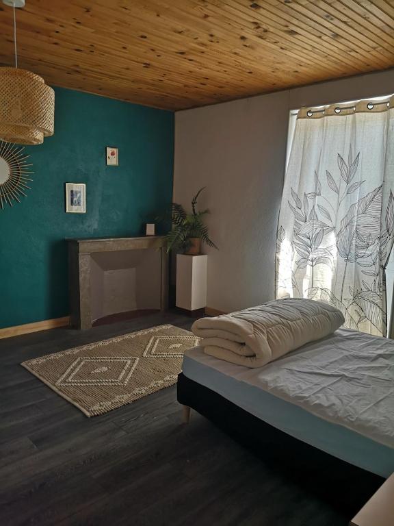 a bedroom with a bed with a window and a fireplace at Maison proche centre Les Vans in Les Vans