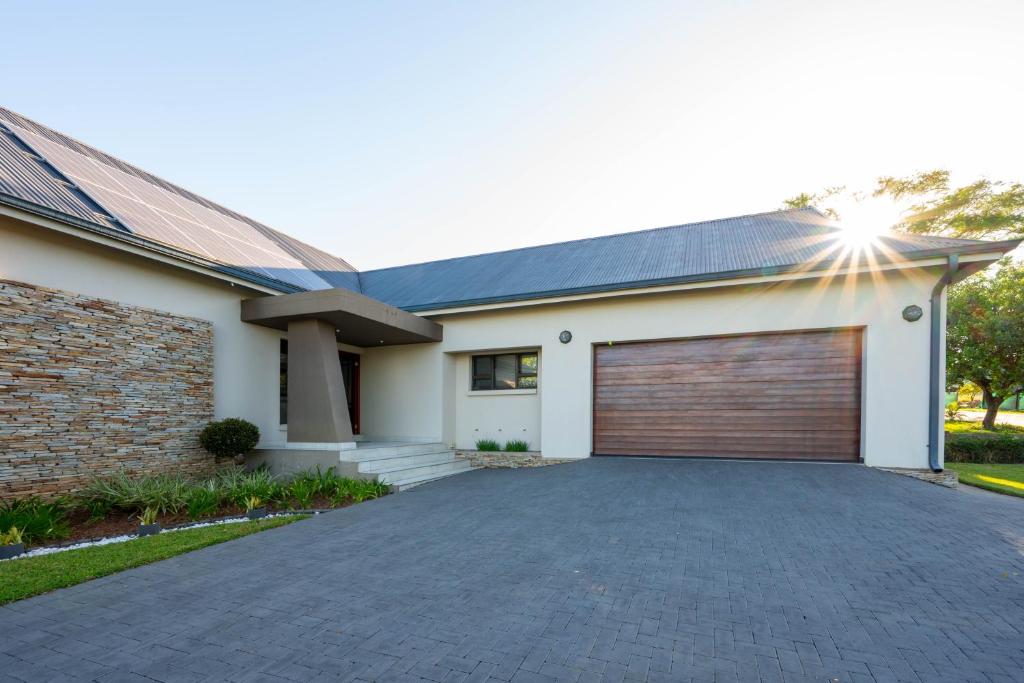 a house with a garage with a driveway at Khaya Elihle Guest House in Hazyview