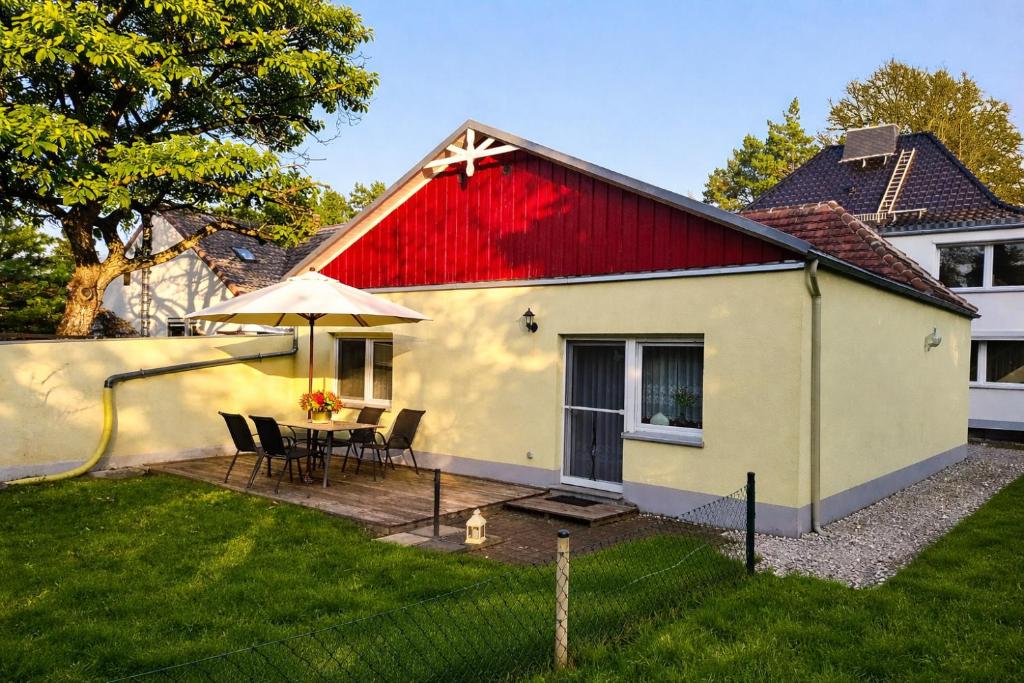 a house with a red roof with a table and chairs at Haus-Sonnenschein - Lausitzer Seenland - Senftenberger See in Senftenberg