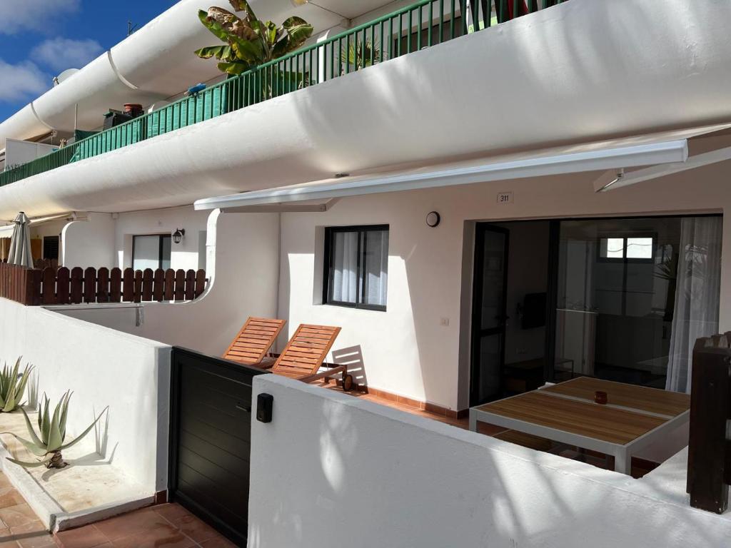 a balcony of a house with chairs and a table at Dunasol 311 in Corralejo