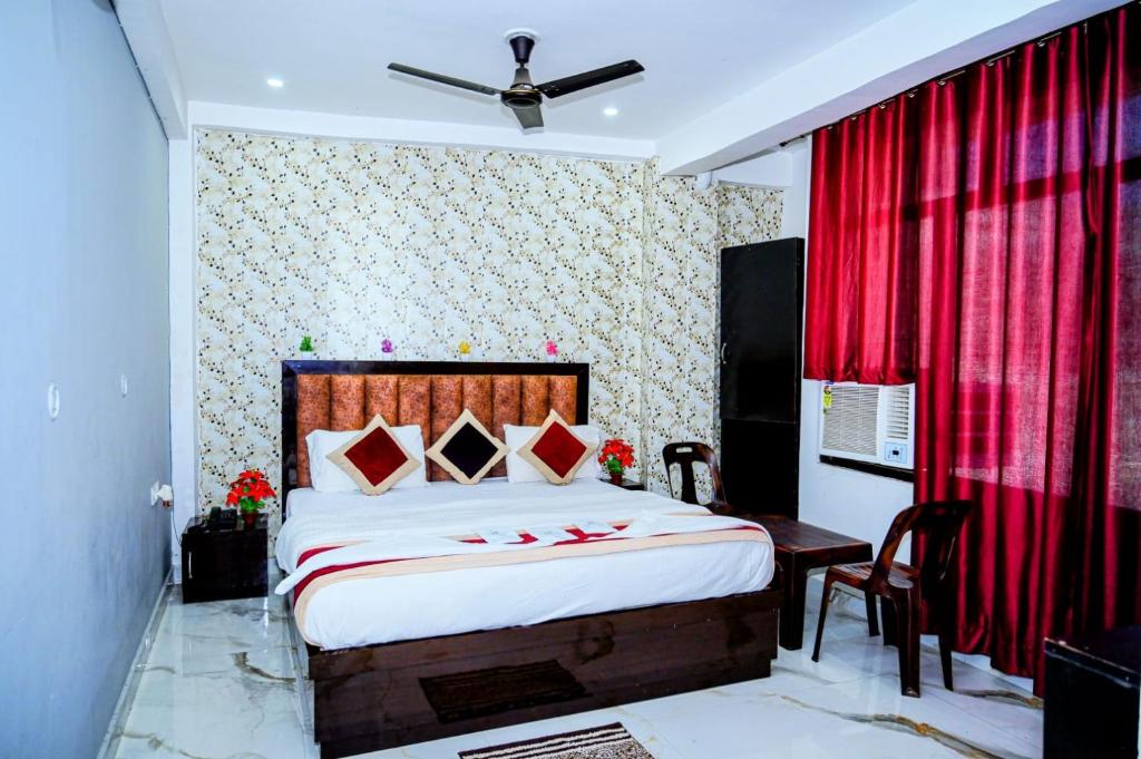 a bedroom with a bed and a red curtain at Hotel Ayodhya in Ayodhya