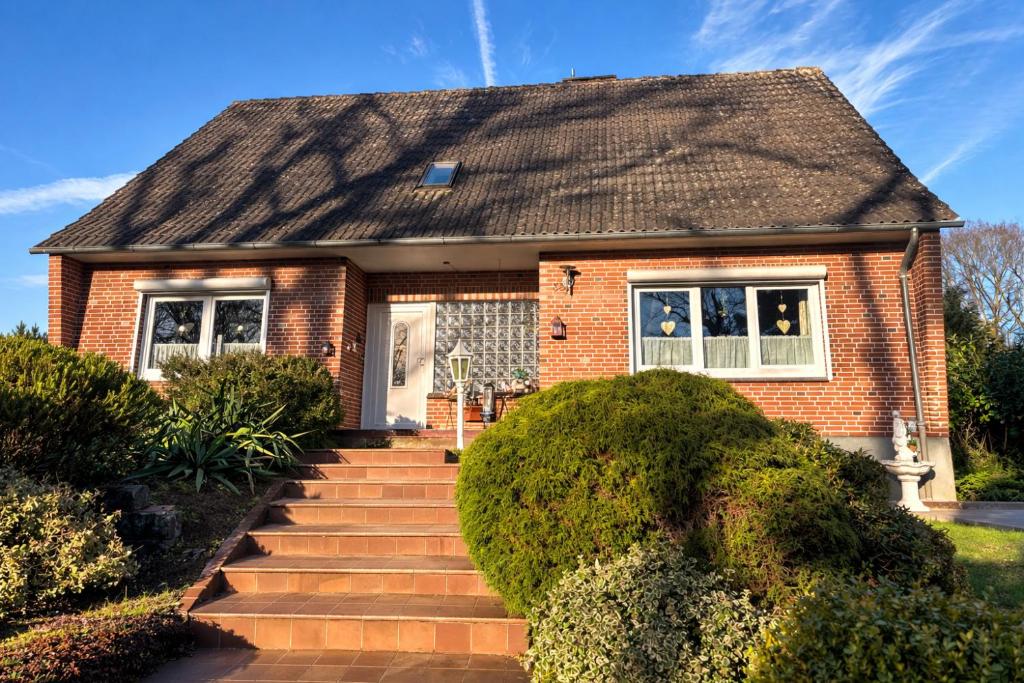 a brick house with a staircase leading to the front door at Gemütliche Ferien oder Monteurs Wohnung in Wallsbüll