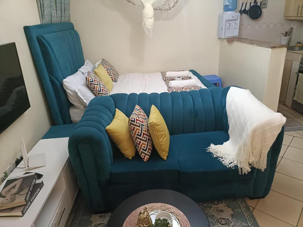 a living room with a blue couch with pillows at Soney Homes in Nairobi