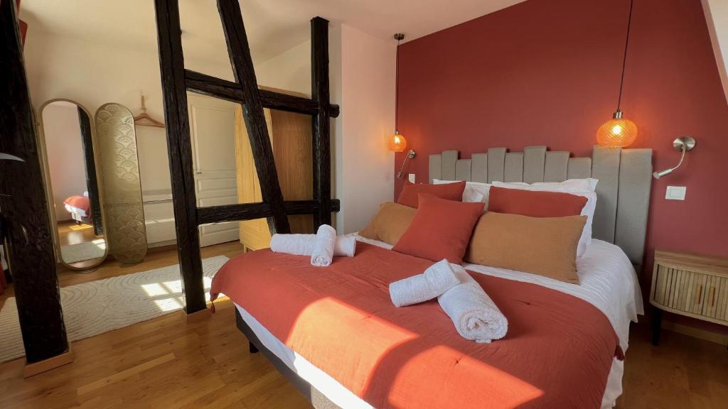 a bedroom with a large bed with towels on it at Appartement Le Verdoyant hyper centre avec Parking et Sauna in Colmar