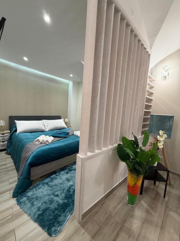 a bedroom with a bed and a vase with a plant at Spataro Home in Catania