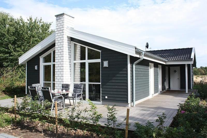 a small house with a table and chairs on a deck at Ferienhaus Grafschafter Perle in Nordhorn