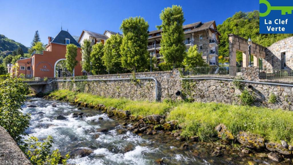 a river in a village with buildings in the background at Résidence Pierre & Vacances Les Trois Domaines in Ax-les-Thermes