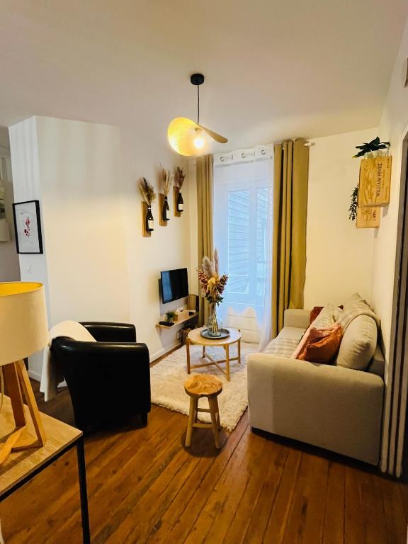 a living room with a couch and a table at Le Petit Millésime - Homillesime in Dijon