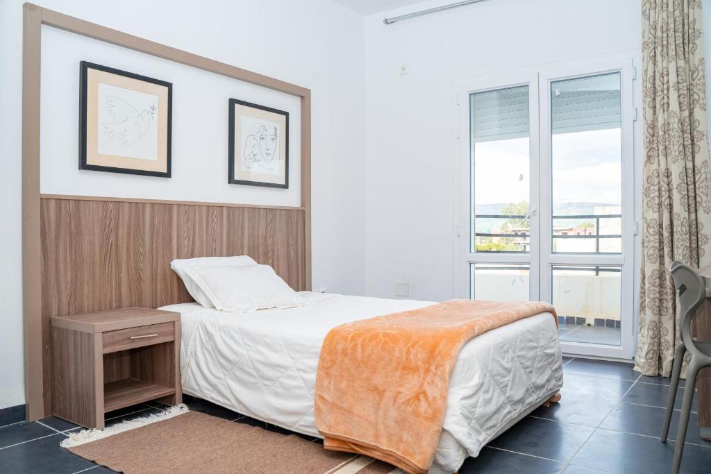 a bedroom with a bed and a window at Rassyl Résidence in Jendouba