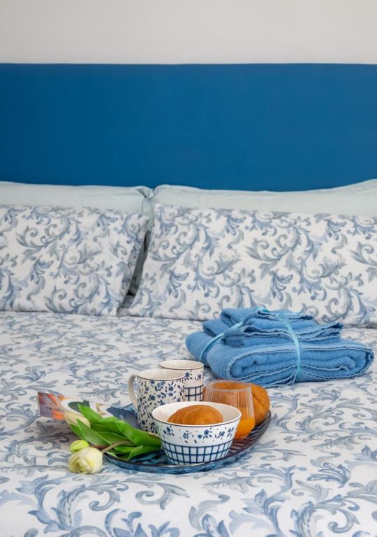 a tray with bowls of food on a bed at APPARTAMENTI TRA CIELO E MARE in Piombino