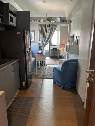 a hallway with a blue couch and a living room at holiday with a maid in Sampong