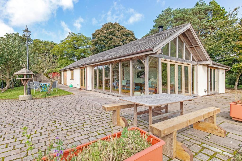 a pavilion with a picnic table in a garden at Amber Lodge in Ashover
