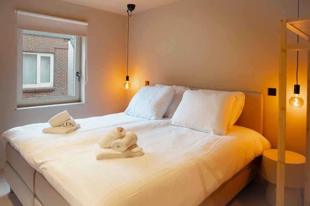 a bedroom with towels on a bed with a window at Studio Strandkasteel, Free parking in Zandvoort