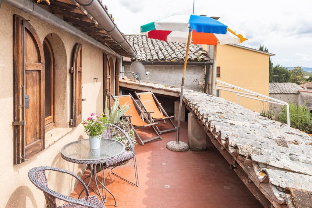 a patio with a table and an umbrella on a balcony at Sunset and lake in Bolsena