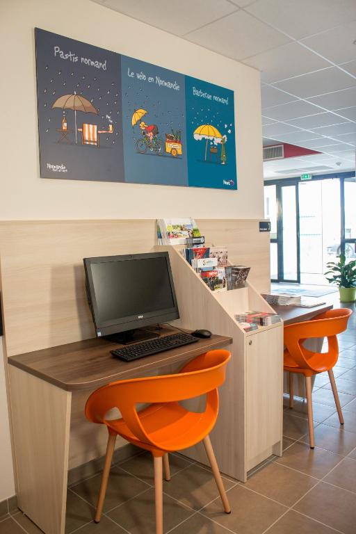 an office with a desk with a computer and orange chairs at Ace Hôtel Caen Nord Mémorial in Caen