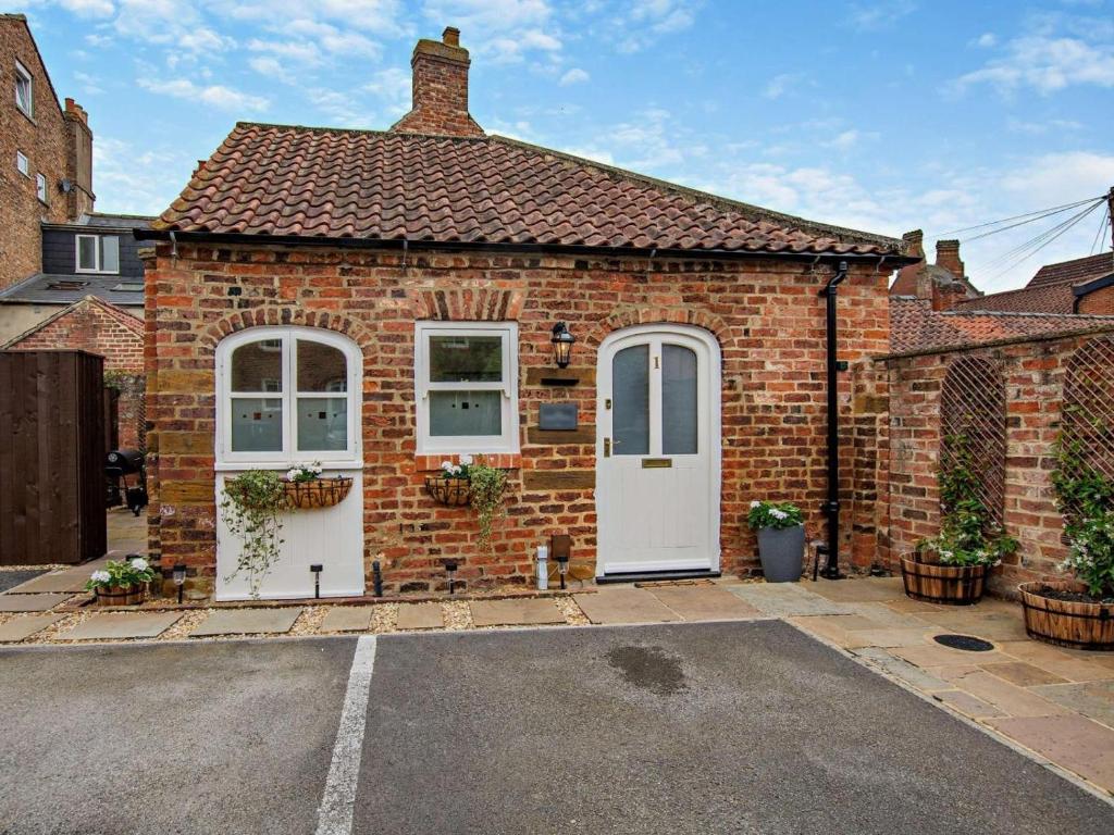a brick house with a white door and windows at 1 Bed in Thirsk oc-94728 in Thirsk