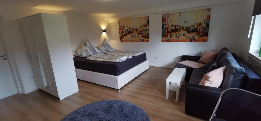 a living room with a bed and a couch at Andreas Zugspitzblick in Murnau am Staffelsee