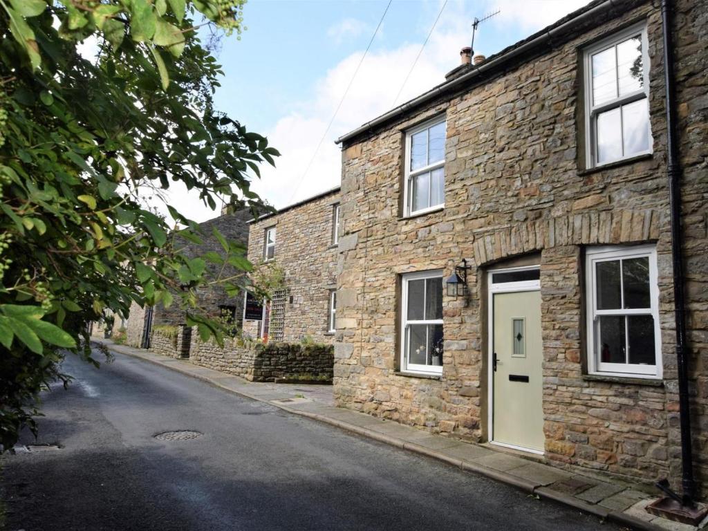 a brick building with a white door on a street at 2 Bed in Leyburn oc-75441 in West Burton