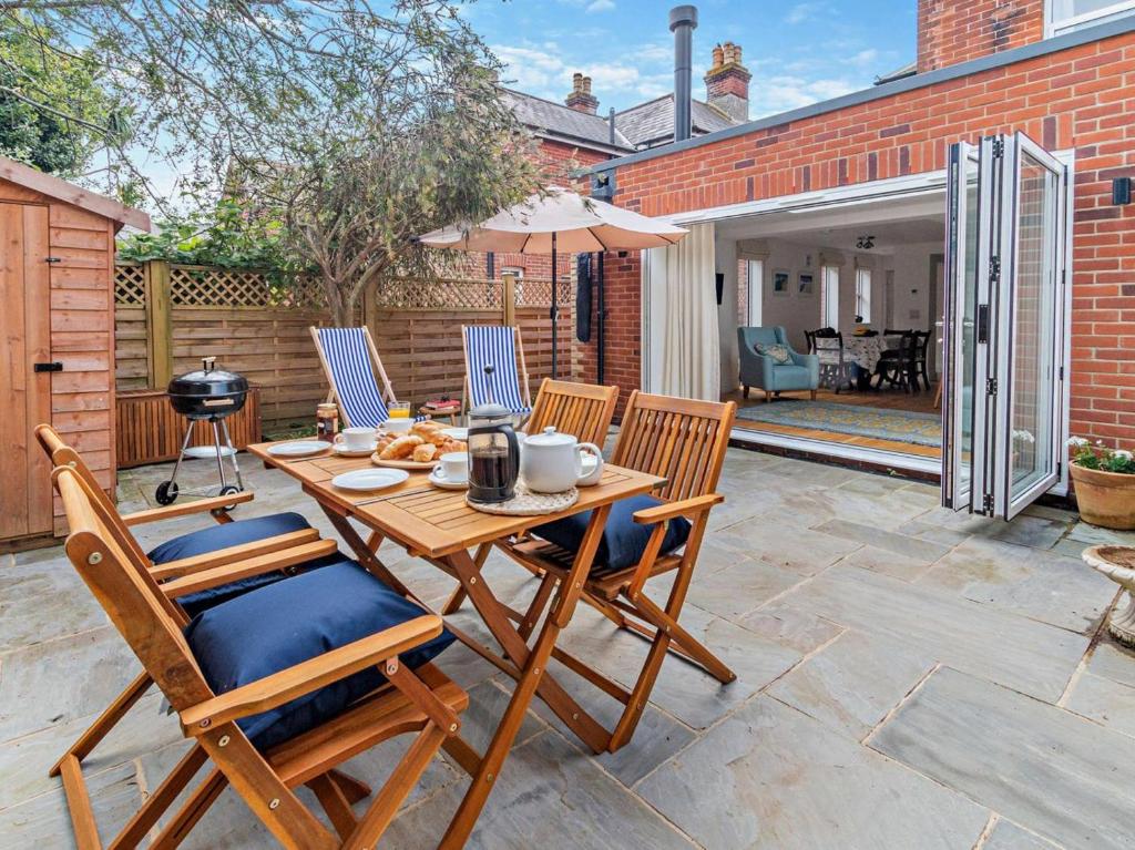 a patio with a wooden table with chairs and an umbrella at 2 Bed in Bembridge oc-94115 in Bembridge