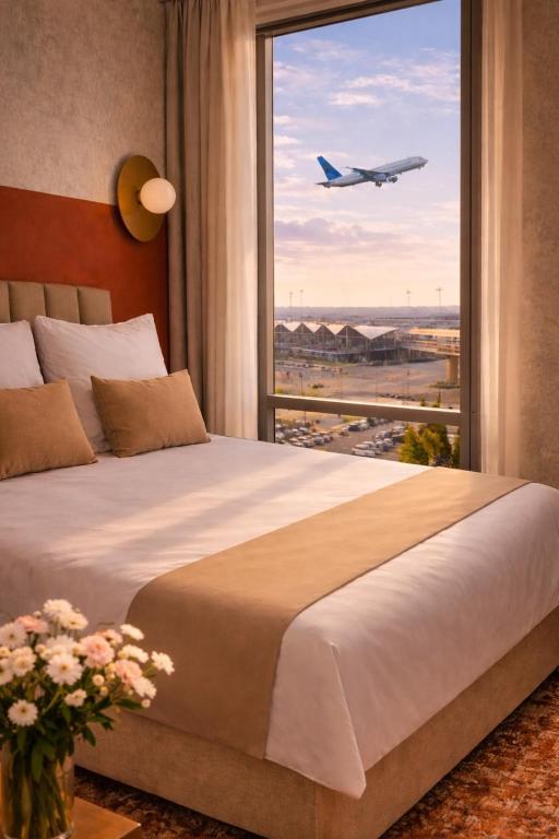 a bedroom with a large window with an airplane taking off at Hotel Milo Gdansk Airport in Gdańsk