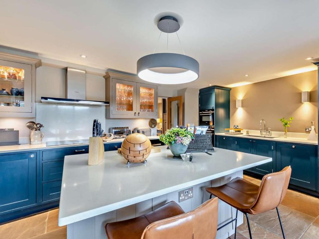 a kitchen with blue cabinets and a large kitchen island at 3 Bed in Leyburn oc-76395 in Askrigg