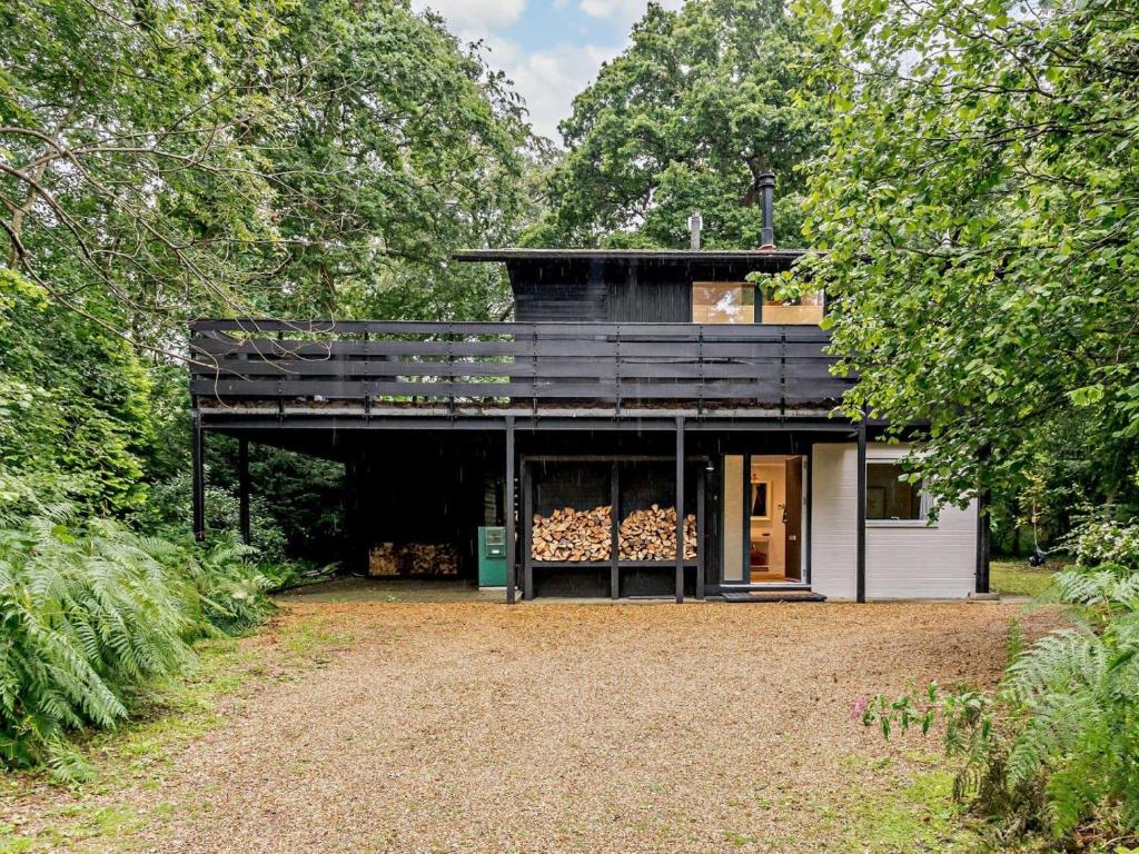 a black house in the middle of a forest at 3 Bed in Brockenhurst oc-47431 in Beaulieu