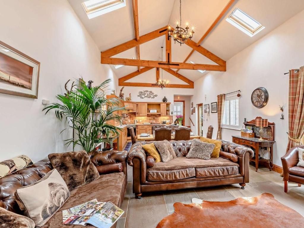 a living room with leather furniture and a ceiling at 3 Bed in Beadnell oc-cn037 in Beadnell