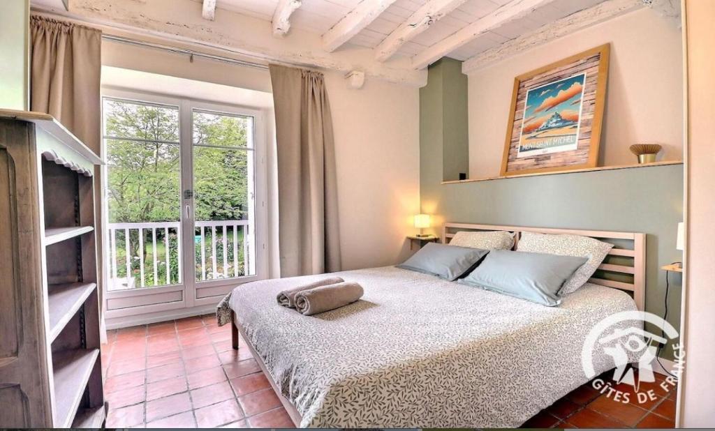 a bedroom with a bed and a large window at Maison d'hôtes KerCalow, Chambres d'hôtes in Pleine-Fougères