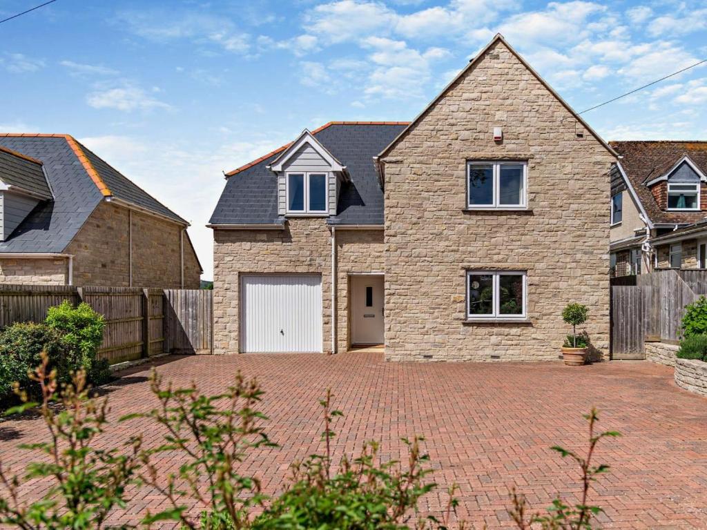 a large brick house with a white garage at 4 Bed in Swanage oc-dc217 in Langton Matravers