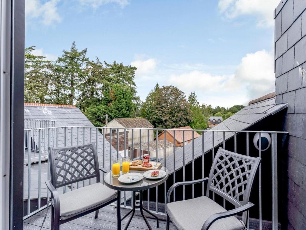 a balcony with two chairs and a table with food on it at 1 Bed in Brockenhurst oc-78730 in Brockenhurst