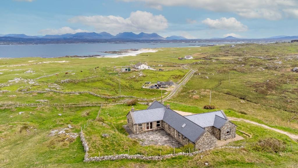 an aerial view of a house on a grassy field at Diamond Cottage in Ballyconneely