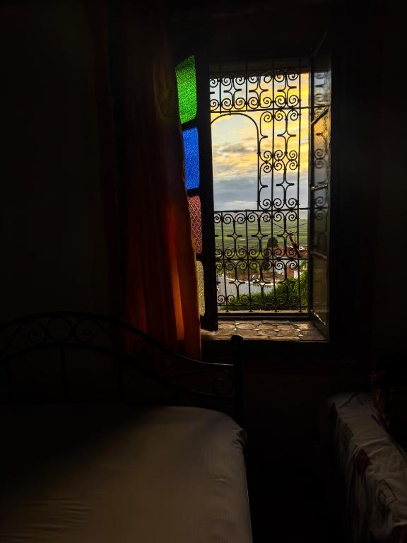 a room with a window with a bed and a view at Chambres et table d'hôtes Caracalla in Douar Doukkara