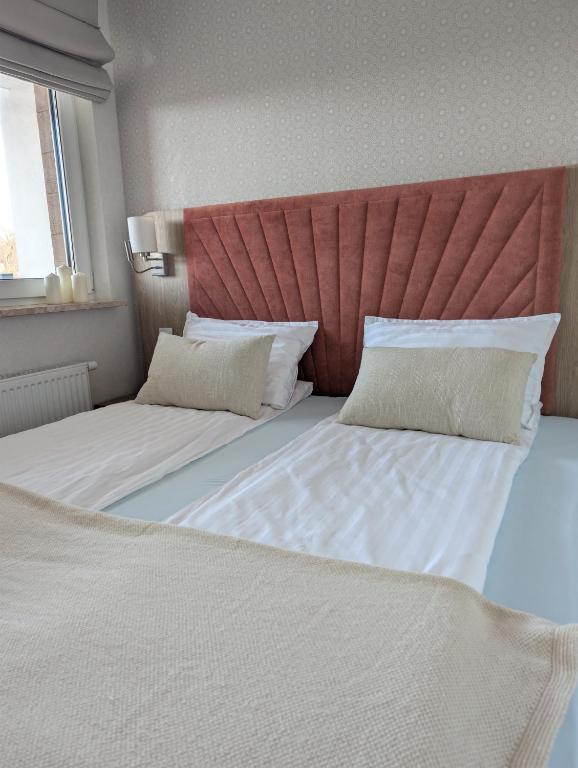 a bedroom with two beds and a red headboard at BelMare 327 Aqua in Międzyzdroje