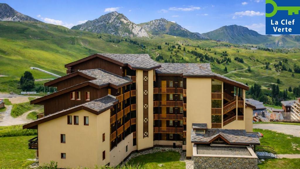 an apartment building with mountains in the background at Résidence Pierre & Vacances Les Constellations in Belle Plagne