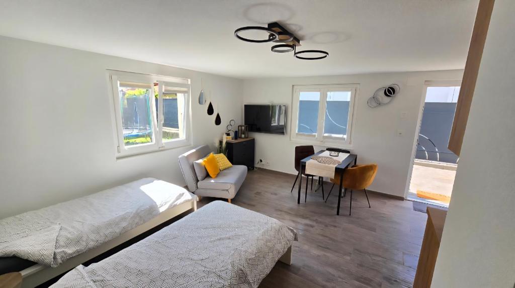a bedroom with a bed and a chair and a table at Le Petit Beurre de cacahuète et Le Poivre et Sel in Fully