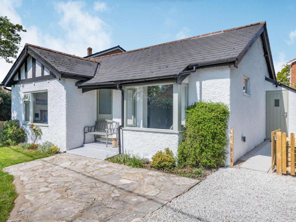 a small white house with a driveway at 2 Bed in Lymington oc-87885 in Sway