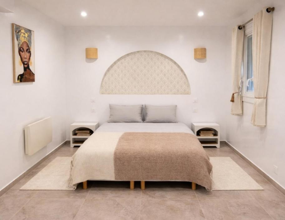 a bedroom with a large bed with two tables at Elohan Suite, parenthèse chic & cosy in Pontoise