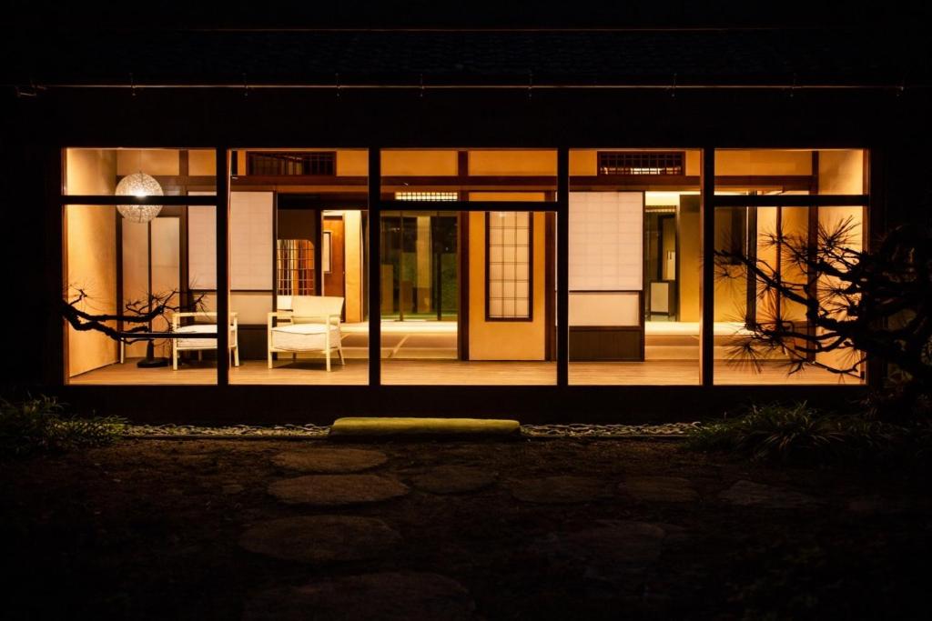 a house with glass doors and a table and chairs at 宮島 Shinwa in Miyajima
