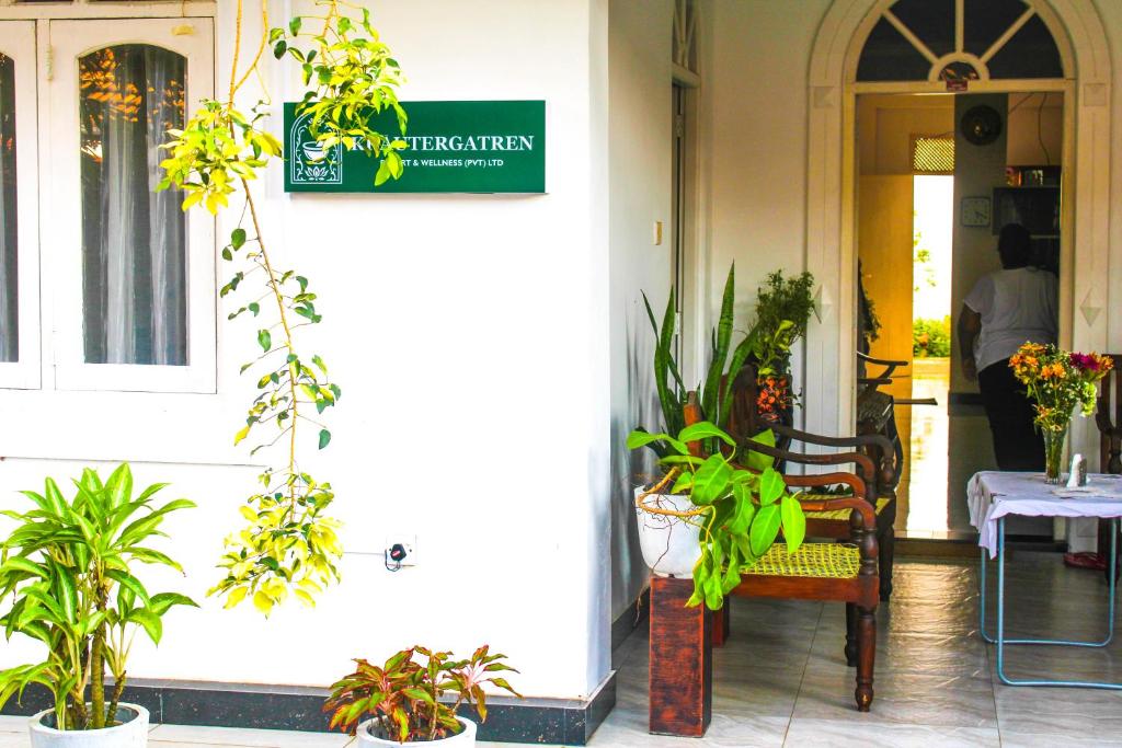 a sign on the side of a building with plants at Krautergarten Resort & Wellness in Negombo
