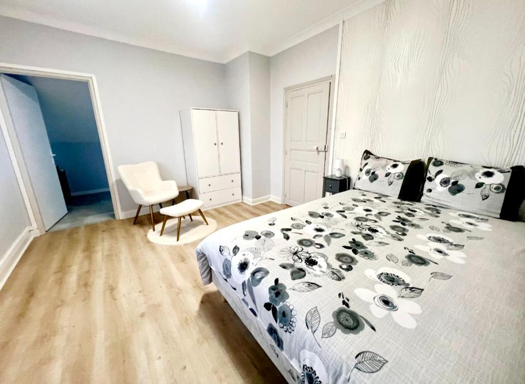 a bedroom with a black and white bed and a chair at Chambre avec Salle de Bain Privative in Tarbes