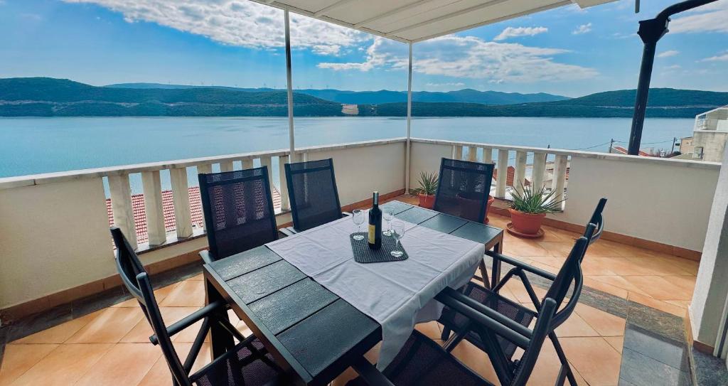 a table and chairs on a balcony with a view of the water at Villa Tex in Neum