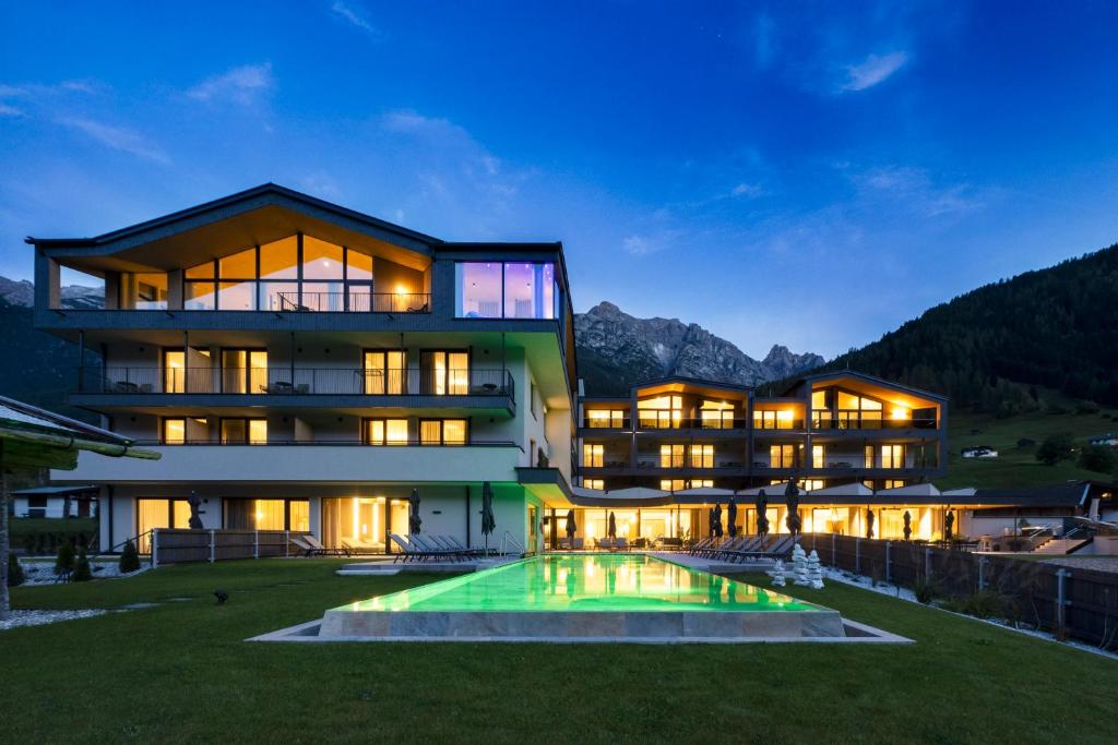 a large house with a pool in front of it at ELVA PREMIUM APARTMENT HOTEL inklusive Sommerpass STUBAI SUPER CARD in Neustift im Stubaital