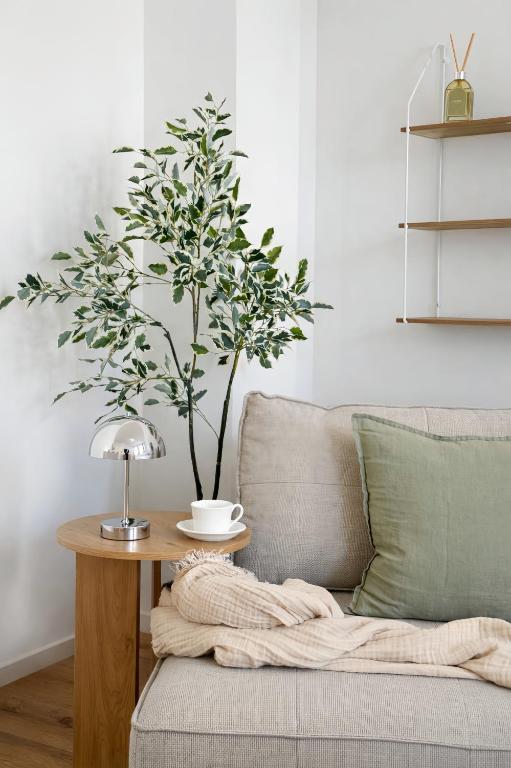 a living room with a couch and a table with a tree at Suites am Herzogberg in Brunn am Gebirge