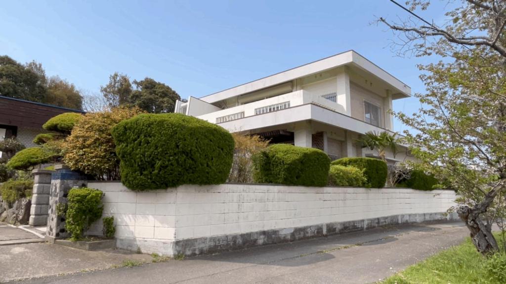a house with bushes on a brick wall at Sane Yanagisawa in Awaji
