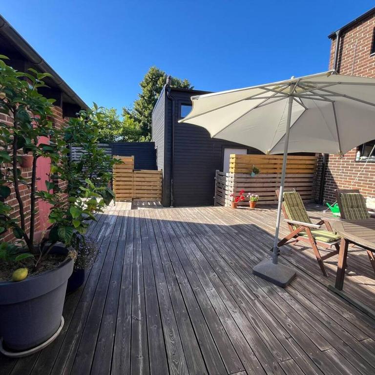 a patio with an umbrella and a table and chairs at Workers Stay - Construction Worker Housing Sweden in Lund